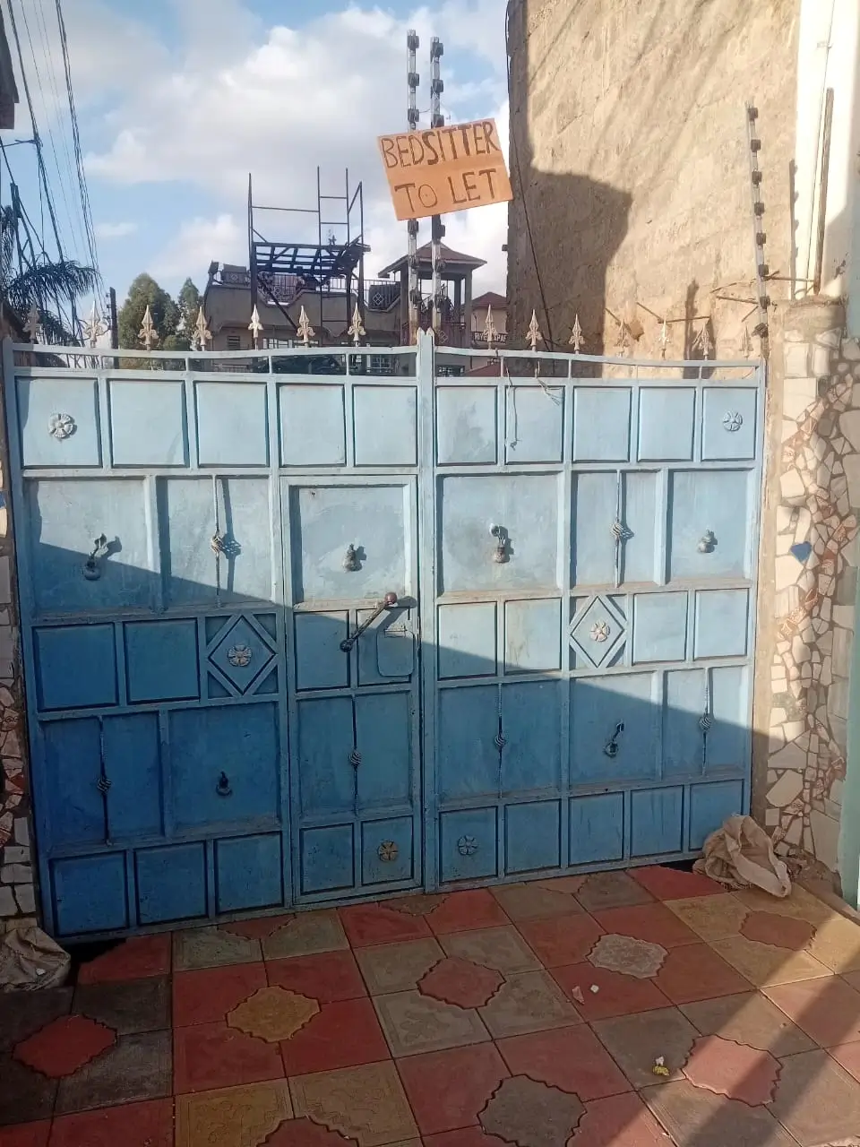 Blue metal garage gate with compound entrance