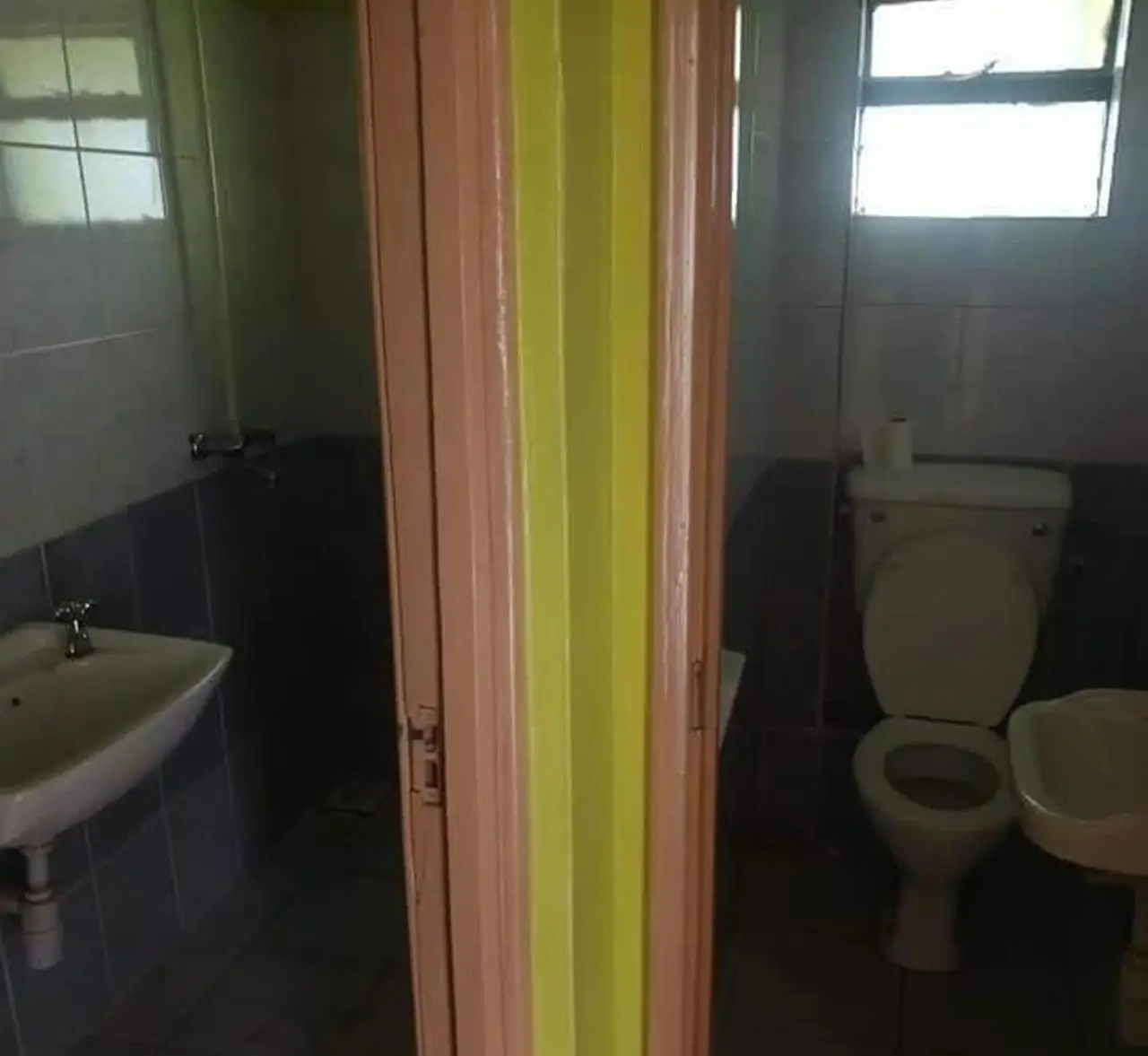 Bathroom with sink, toilet, and colorful partition door