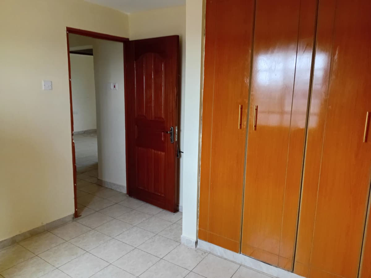 Bedroom entrance with built-in wardrobes and tiled flooring