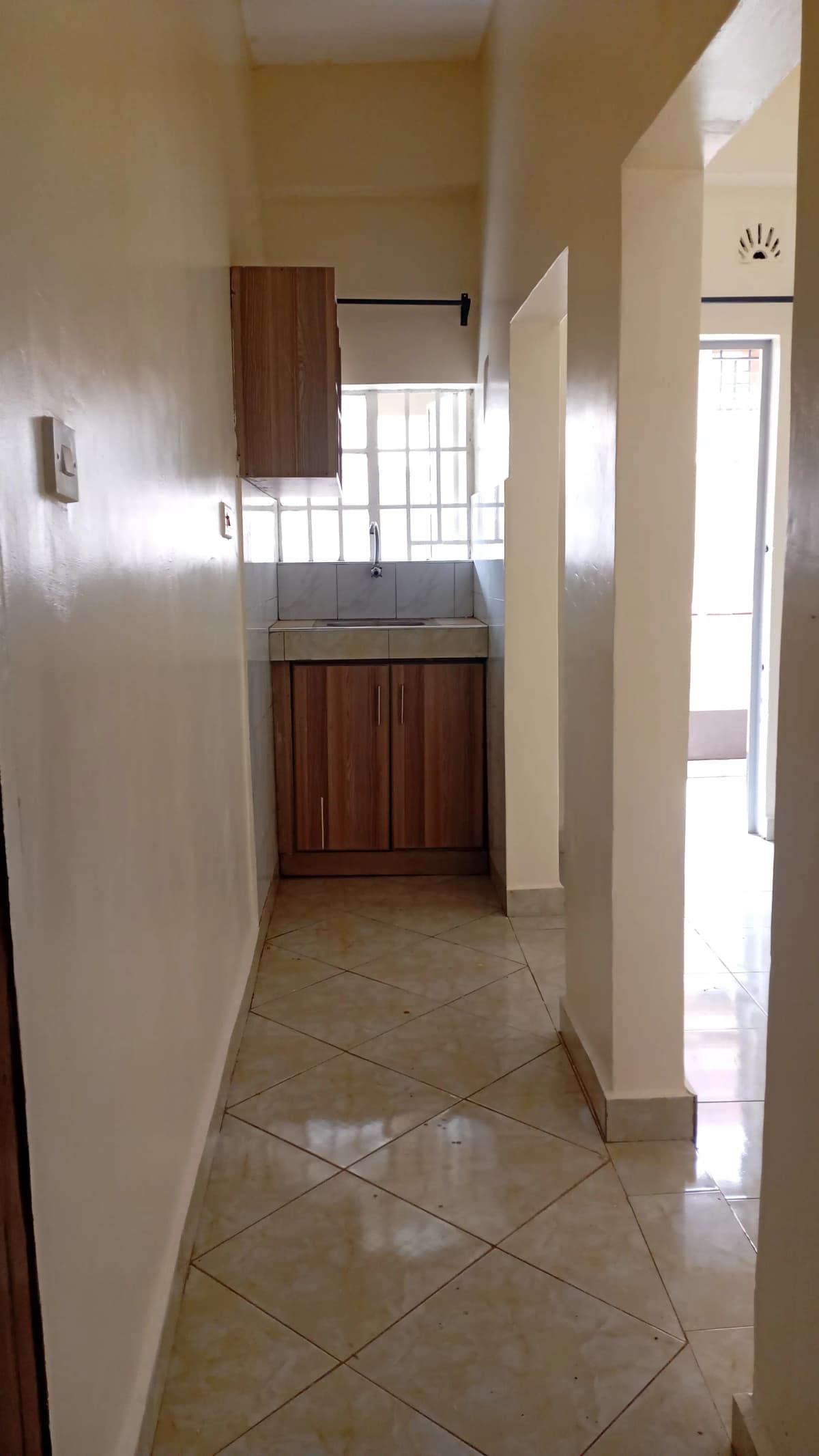 Bright corridor with polished tile flooring and wooden door