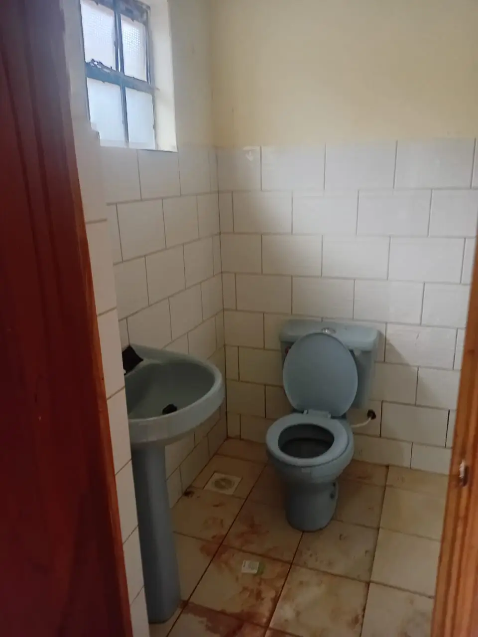 Basic bathroom with toilet, sink, and tiled walls