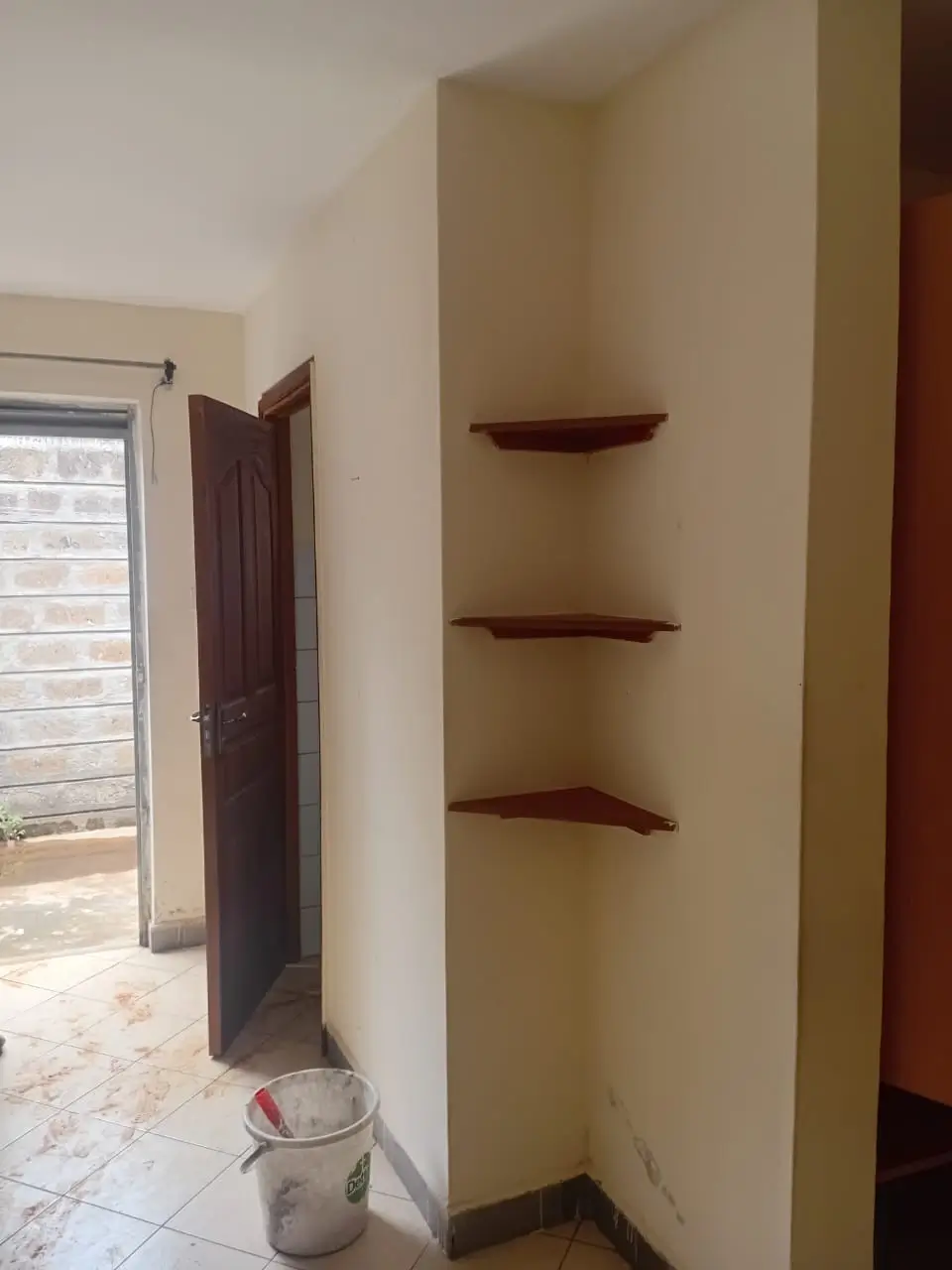 Unfinished interior space with built-in shelving and doorway