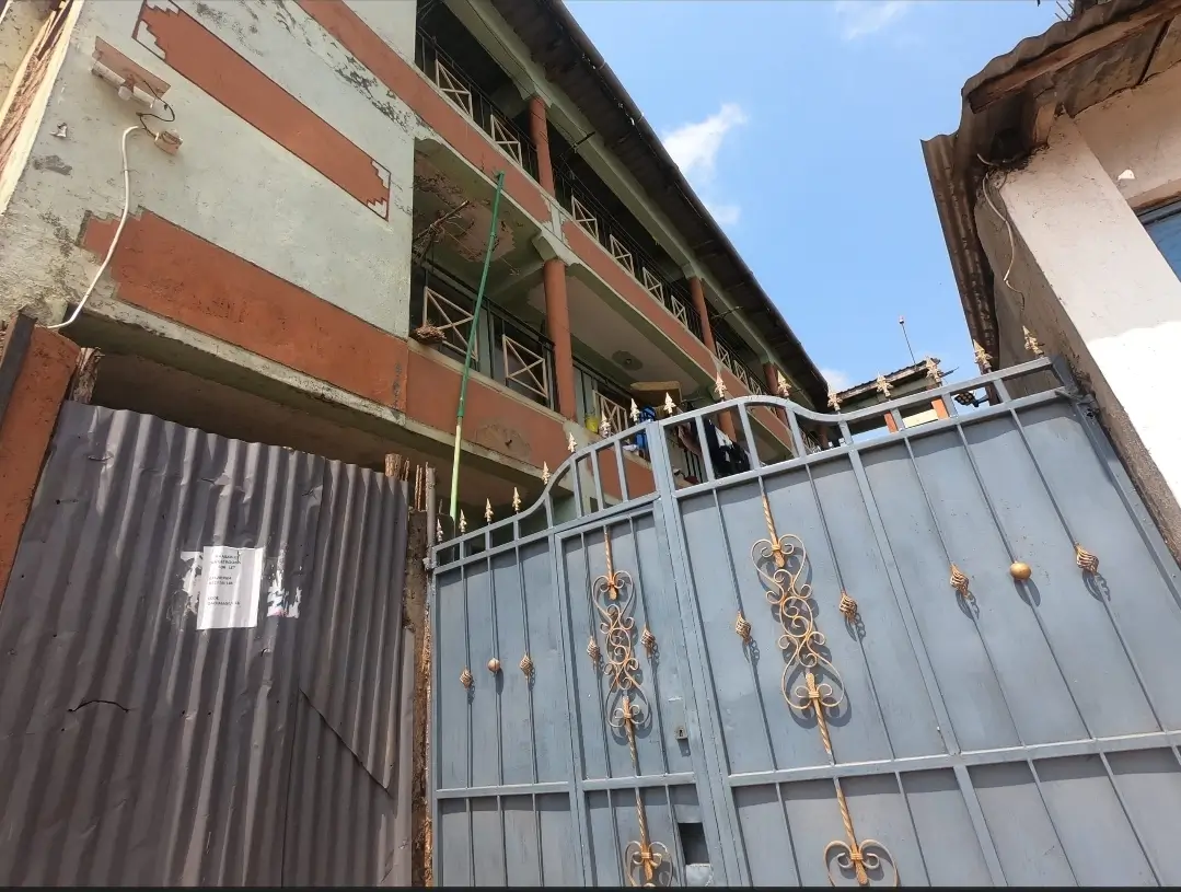 Building facade with decorative metal gate and construction scaffolding