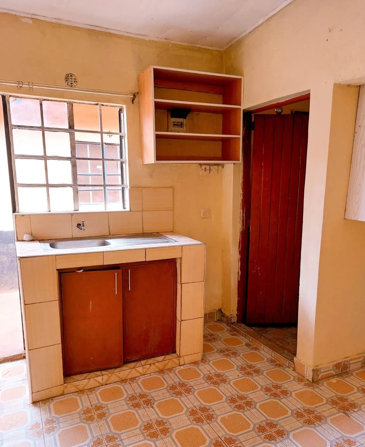 Compact kitchen with red cabinetry and open shelving