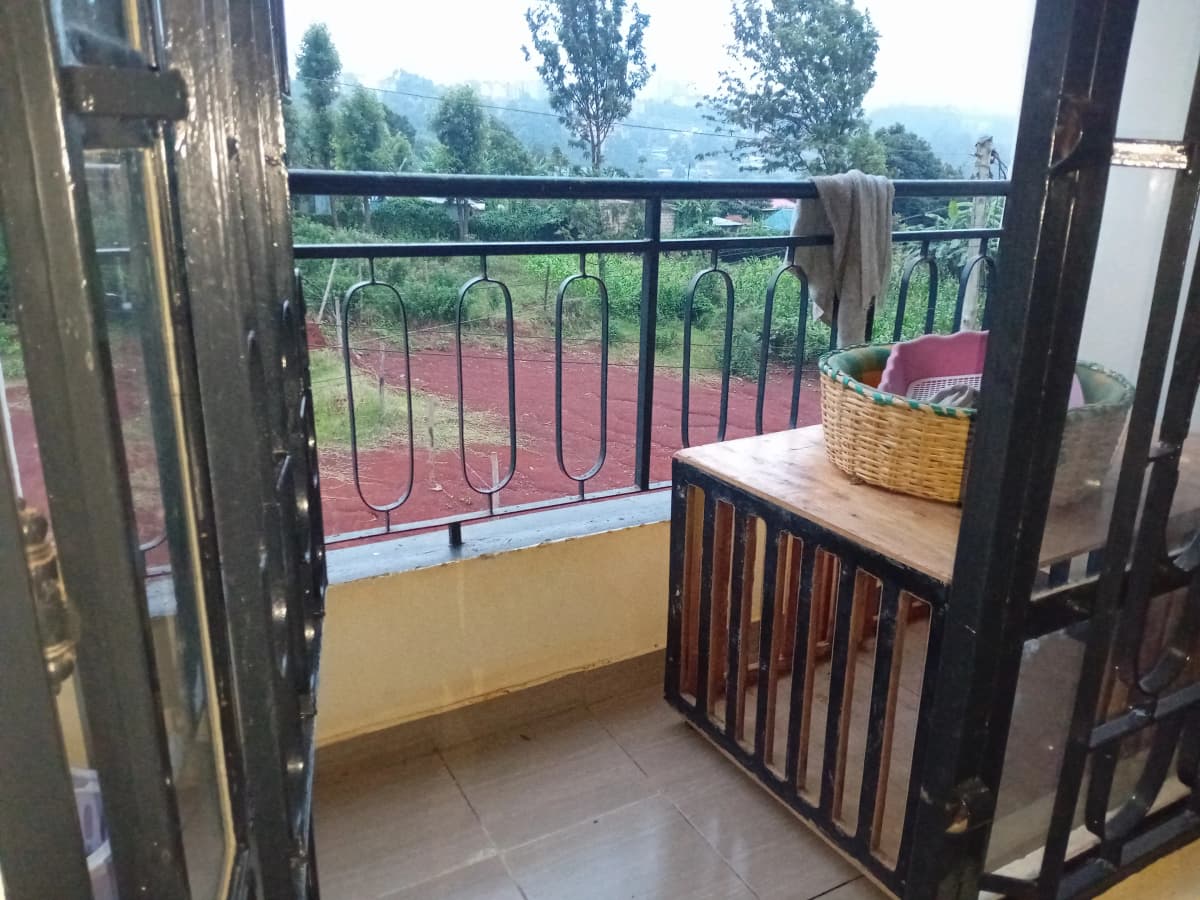 Balcony with metal railing overlooking mountains and gardens