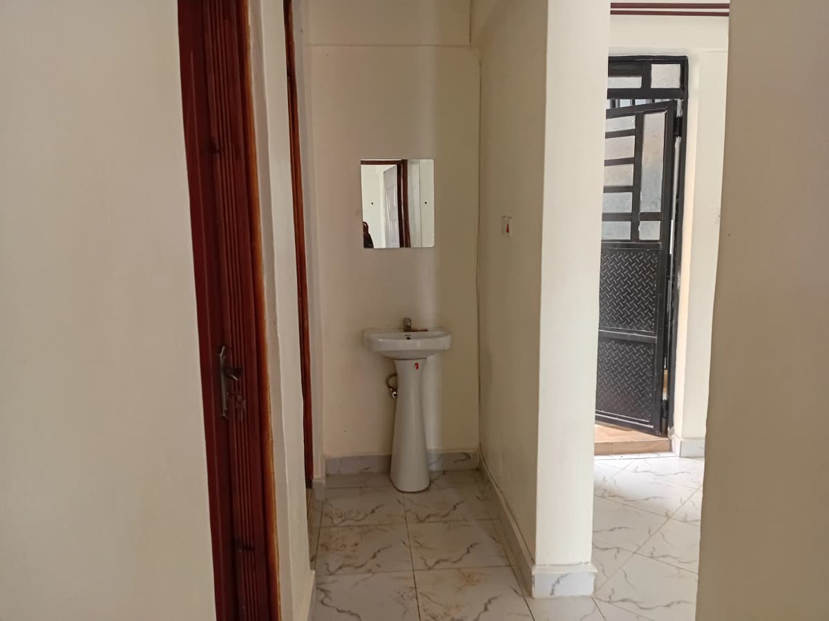 Compact bathroom with pedestal sink and mirror