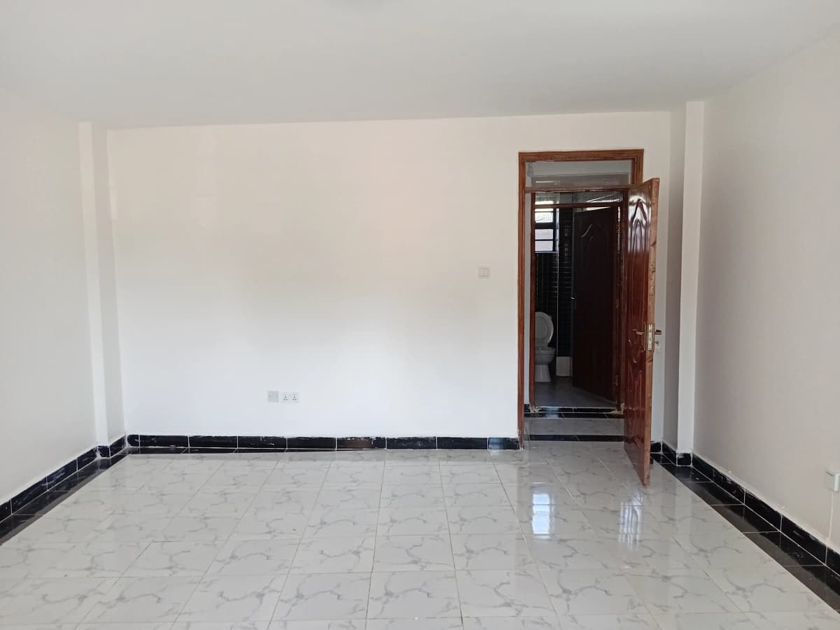 Empty living room with polished tile floor and dark trim