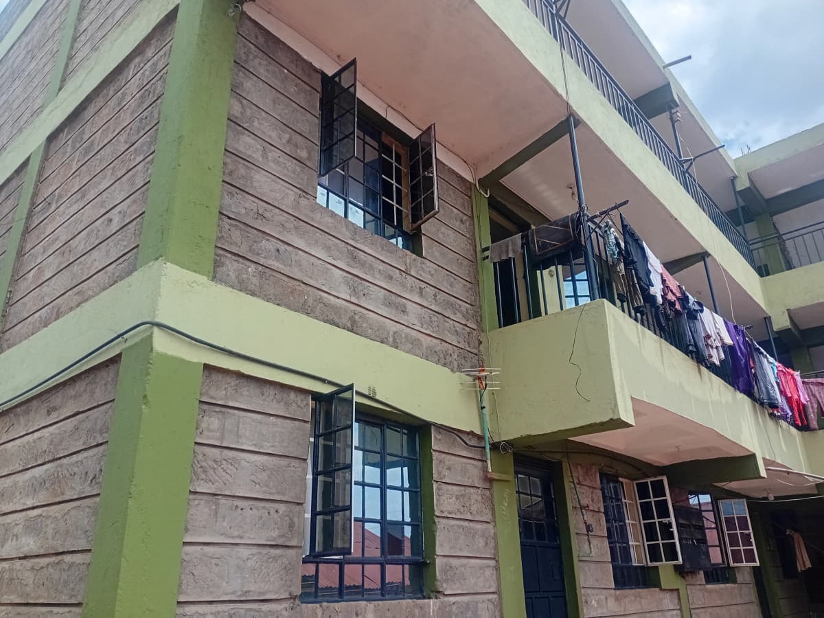 Multi-story residential building with green trim and balconies