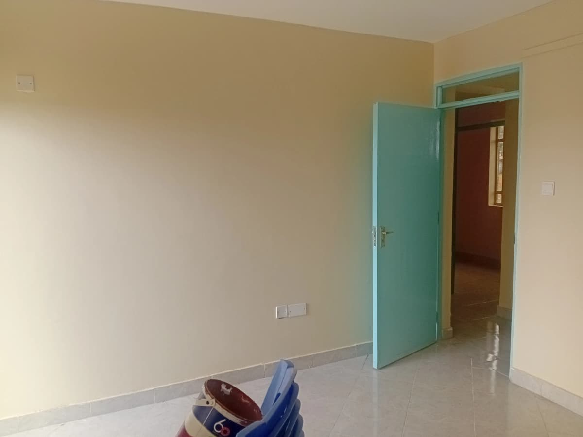 Empty bedroom with turquoise door and polished floor
