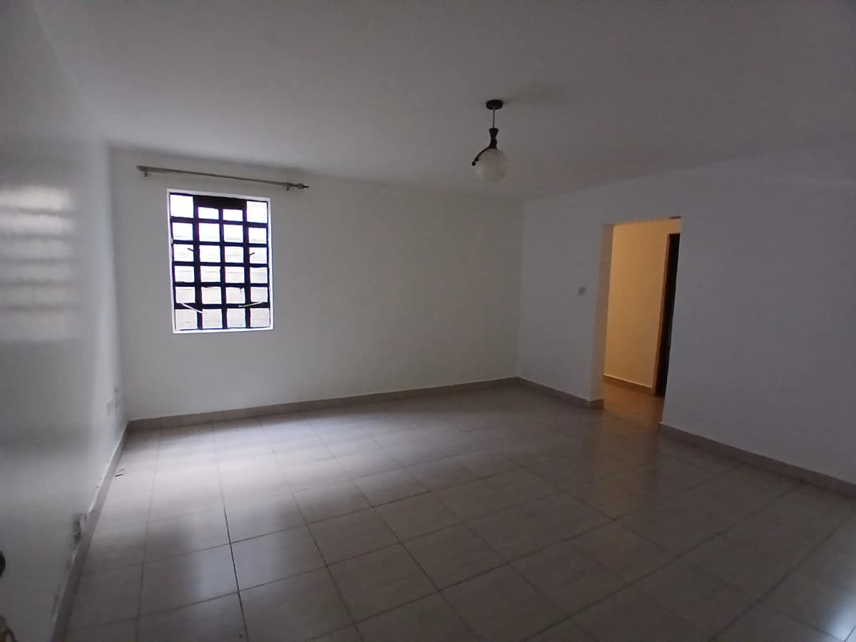Empty living room with barred window and polished concrete floor