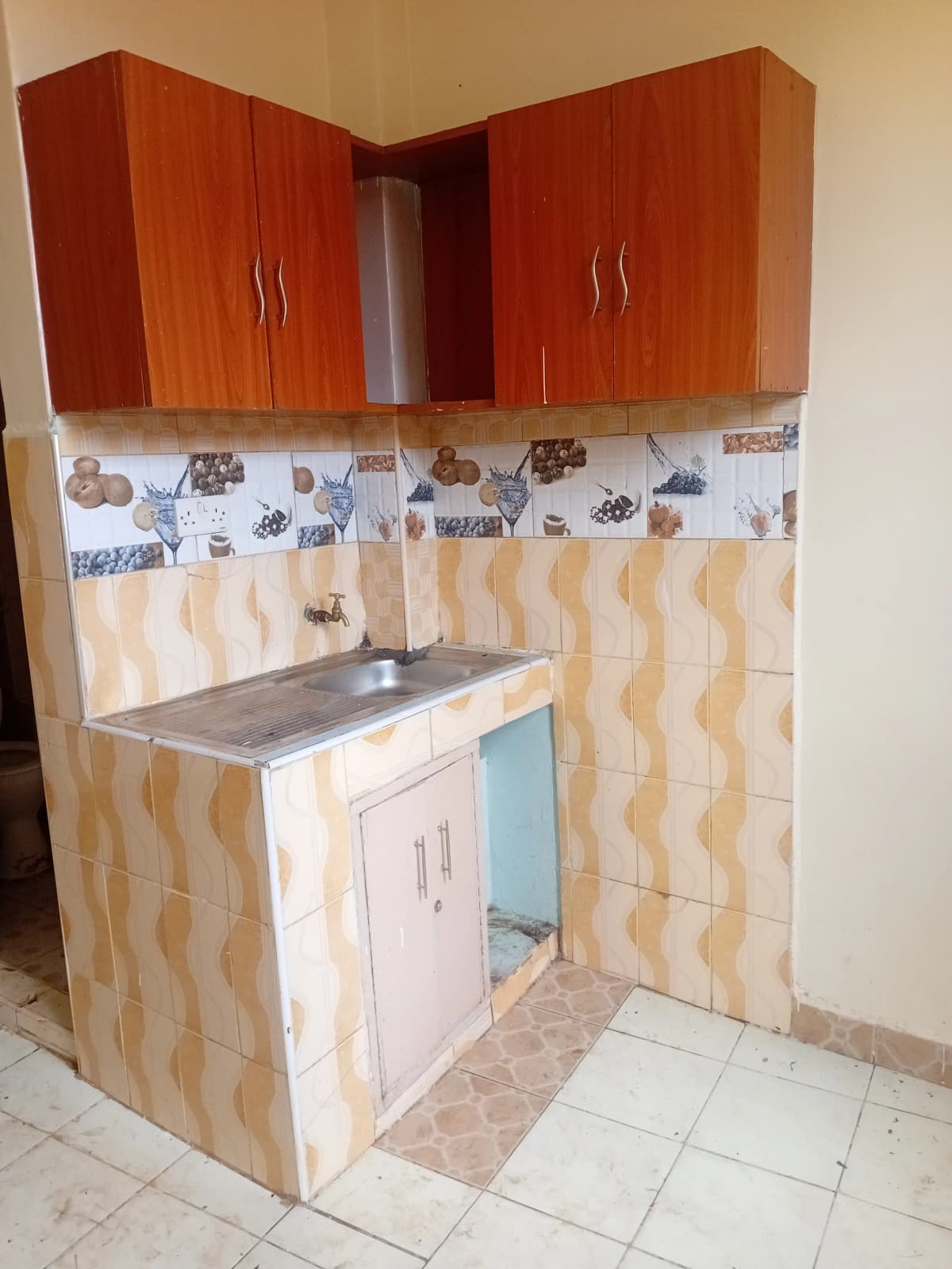 Compact kitchen with wooden cabinets and patterned tile backsplash