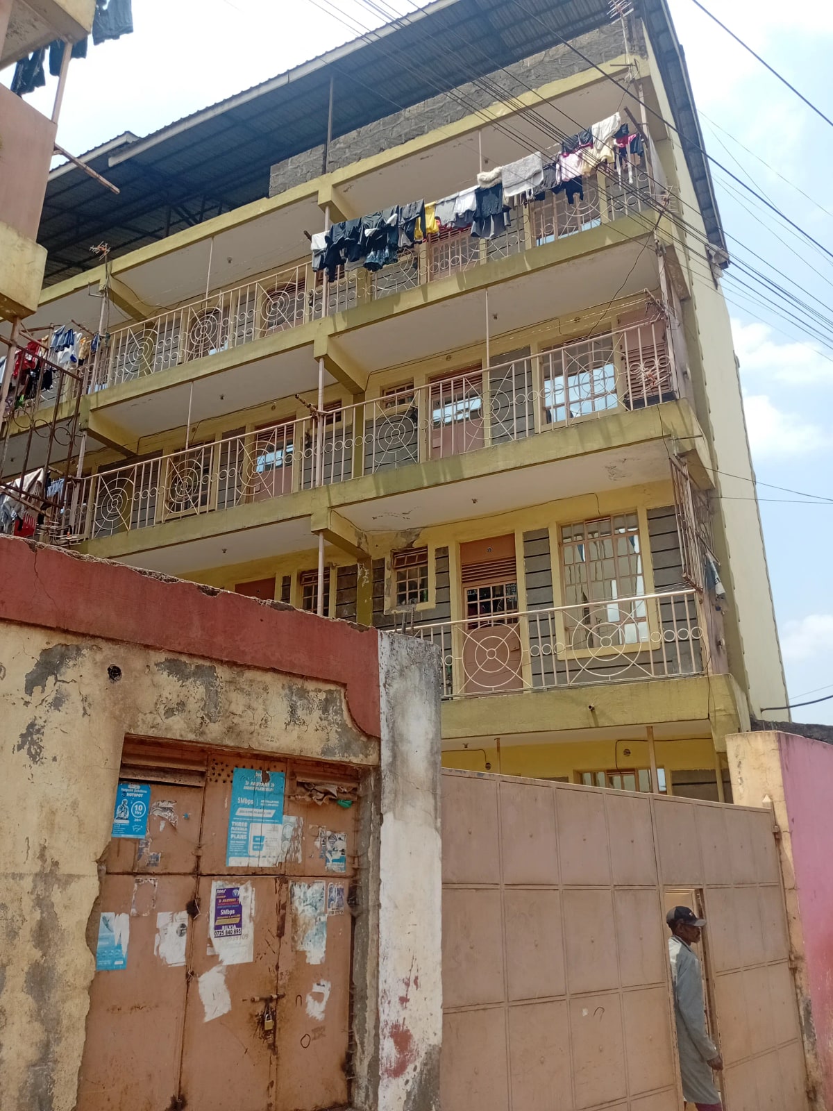 Multi-story residential building facade with balconies and gate