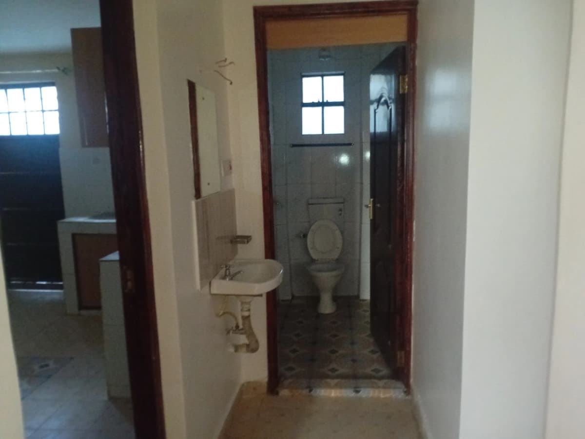 Simple bathroom with toilet, sink, and small window