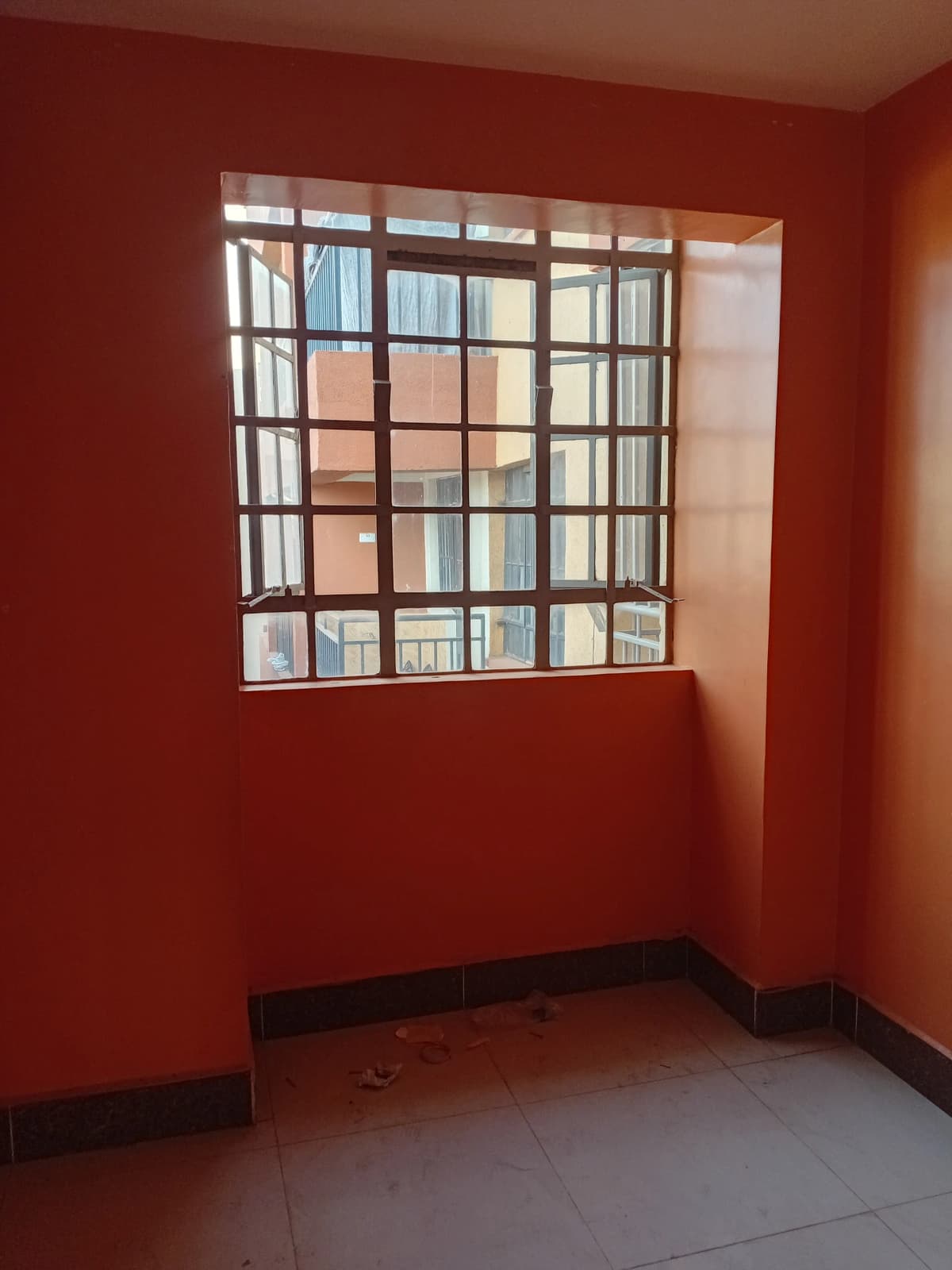 Empty bedroom with red walls and barred window
