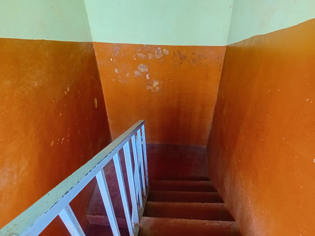 Stairwell with orange walls and metal handrail