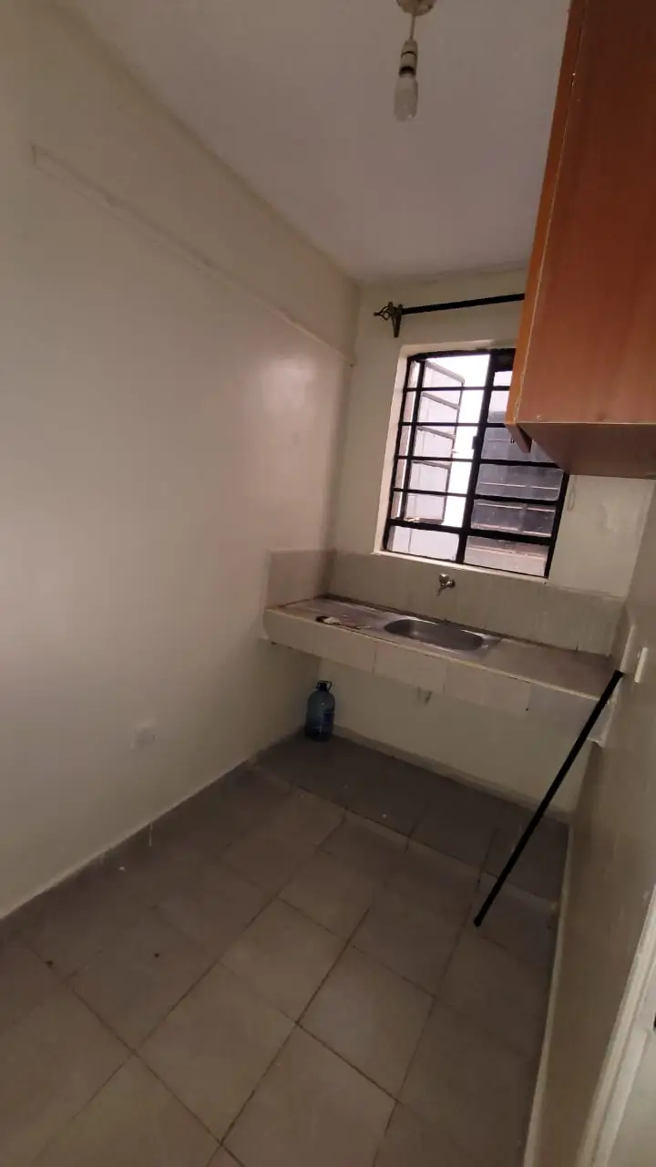 Compact kitchen with basic sink and window, minimal cabinetry