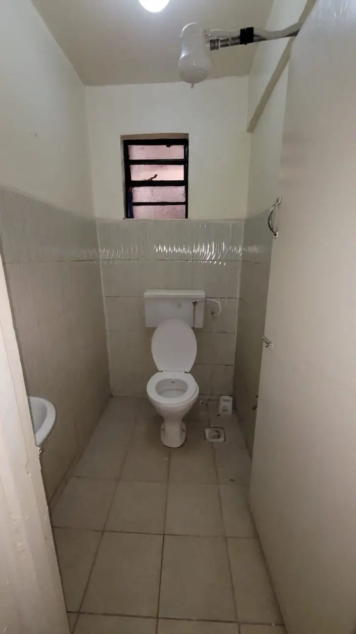 Compact bathroom with toilet and tiled walls