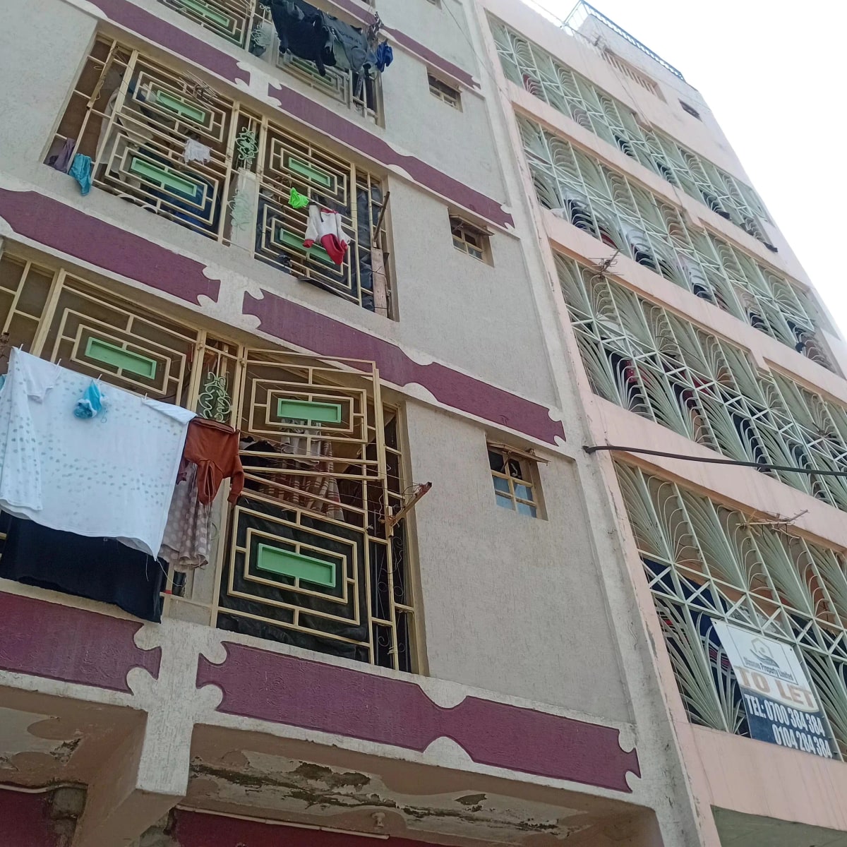 Multi-story residential building facade with purple and white trim
