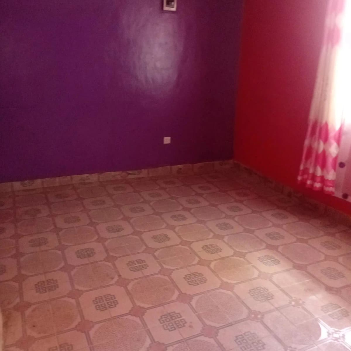 Unfurnished bedroom with purple and red walls, patterned floor
