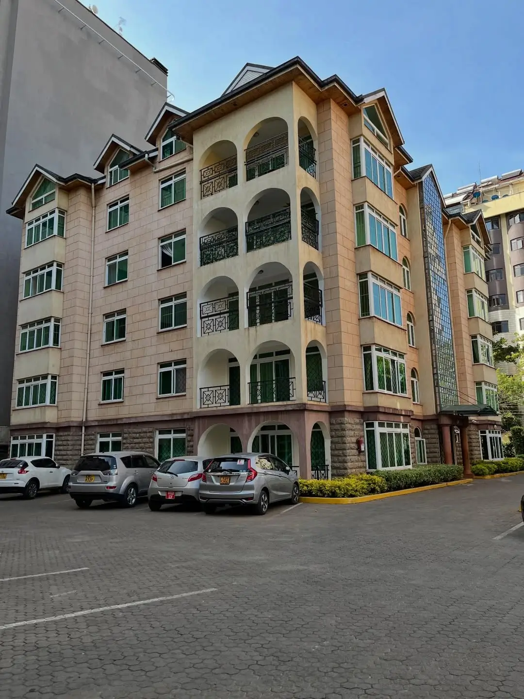 Multi-story residential building with curved balconies and parking lot