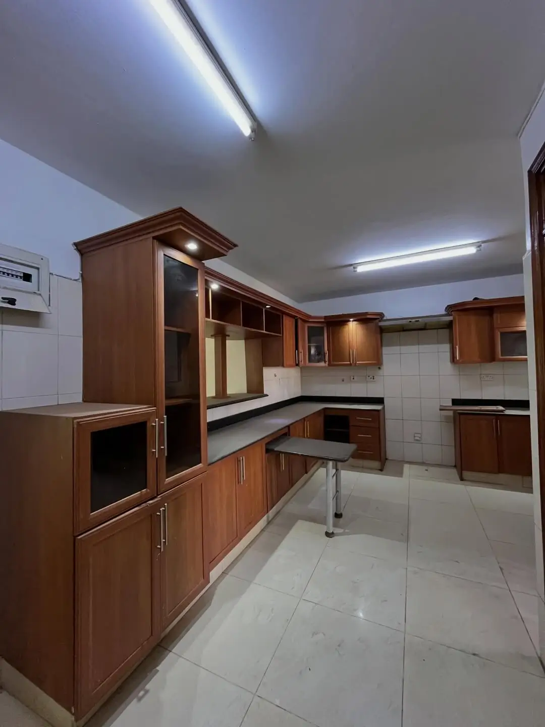 Modern kitchen with wooden cabinetry and white tile flooring