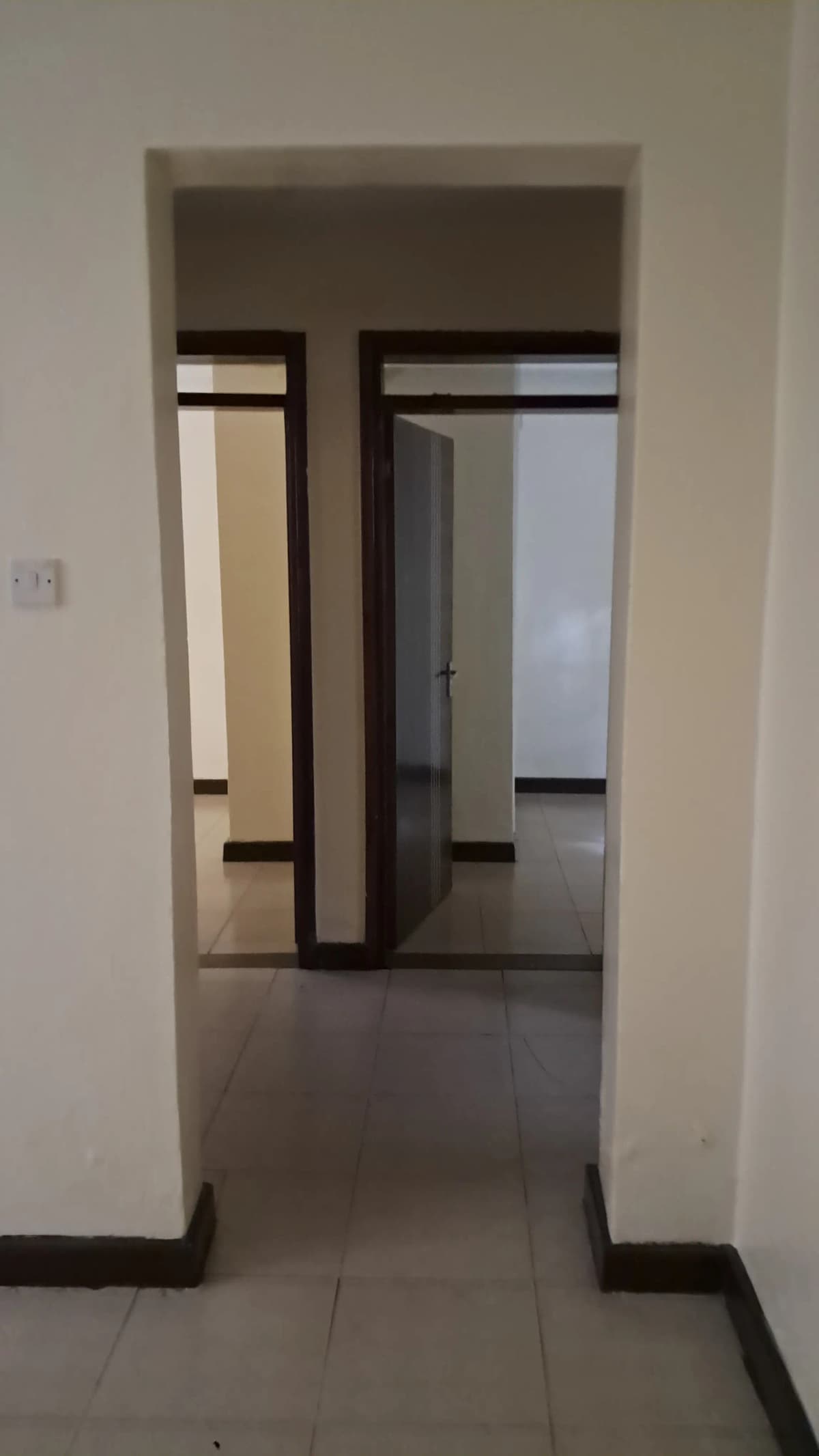 Hallway with open doorways leading to multiple rooms