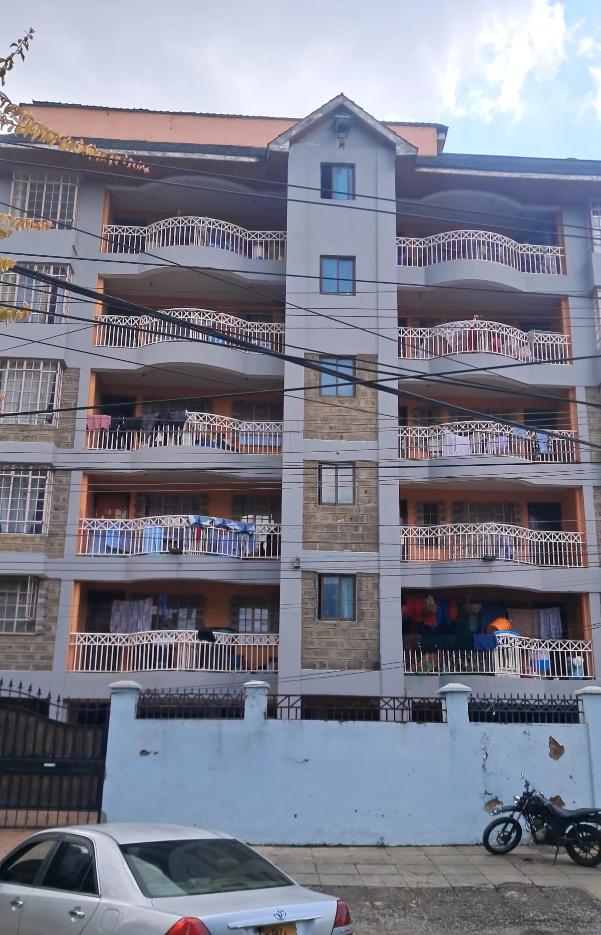 Multi-story residential building with balconies and street parking