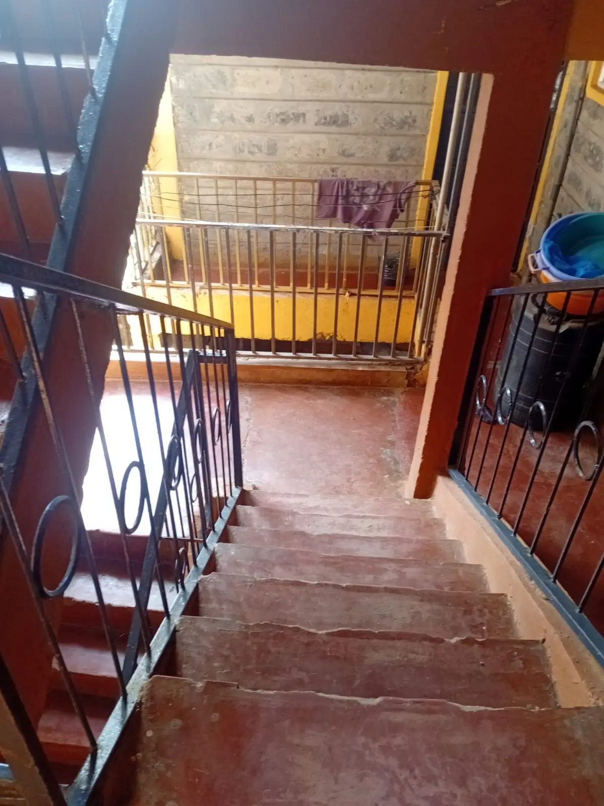 Building corridor with metal railings and red oxide flooring