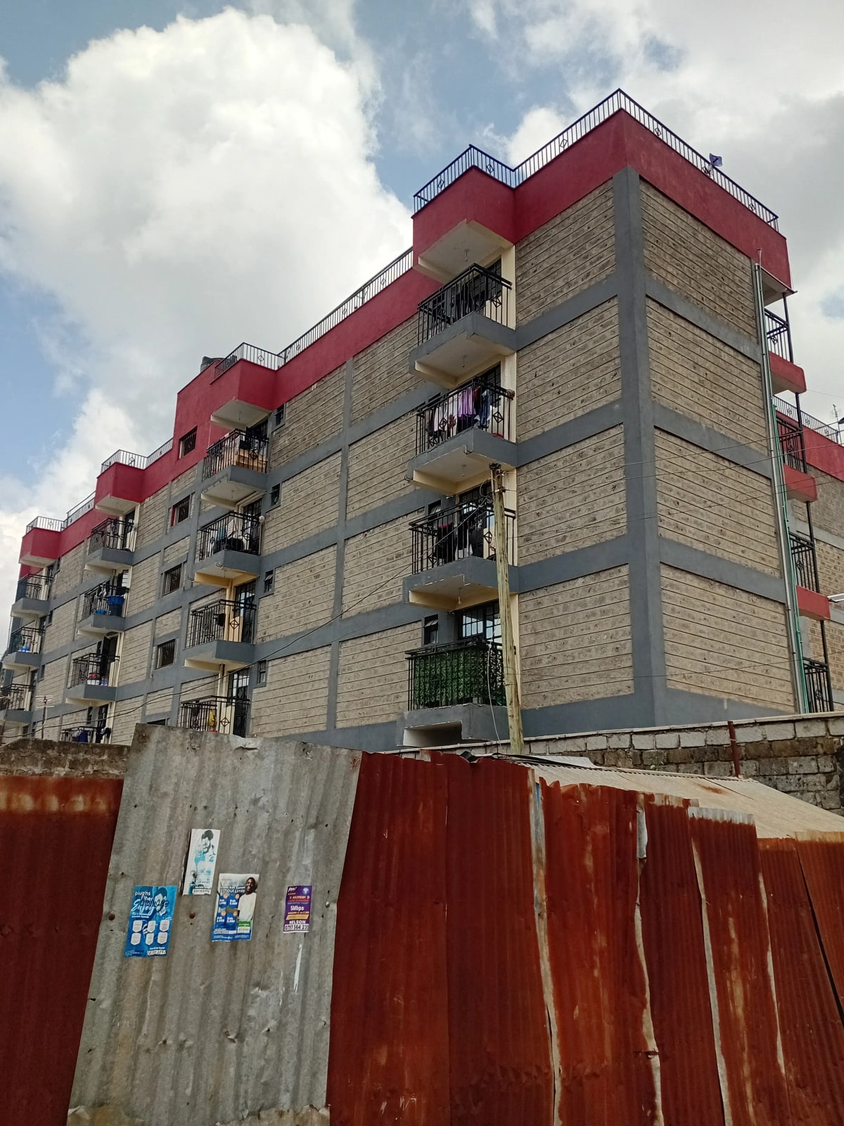Multi-story residential building with red roof accent panels