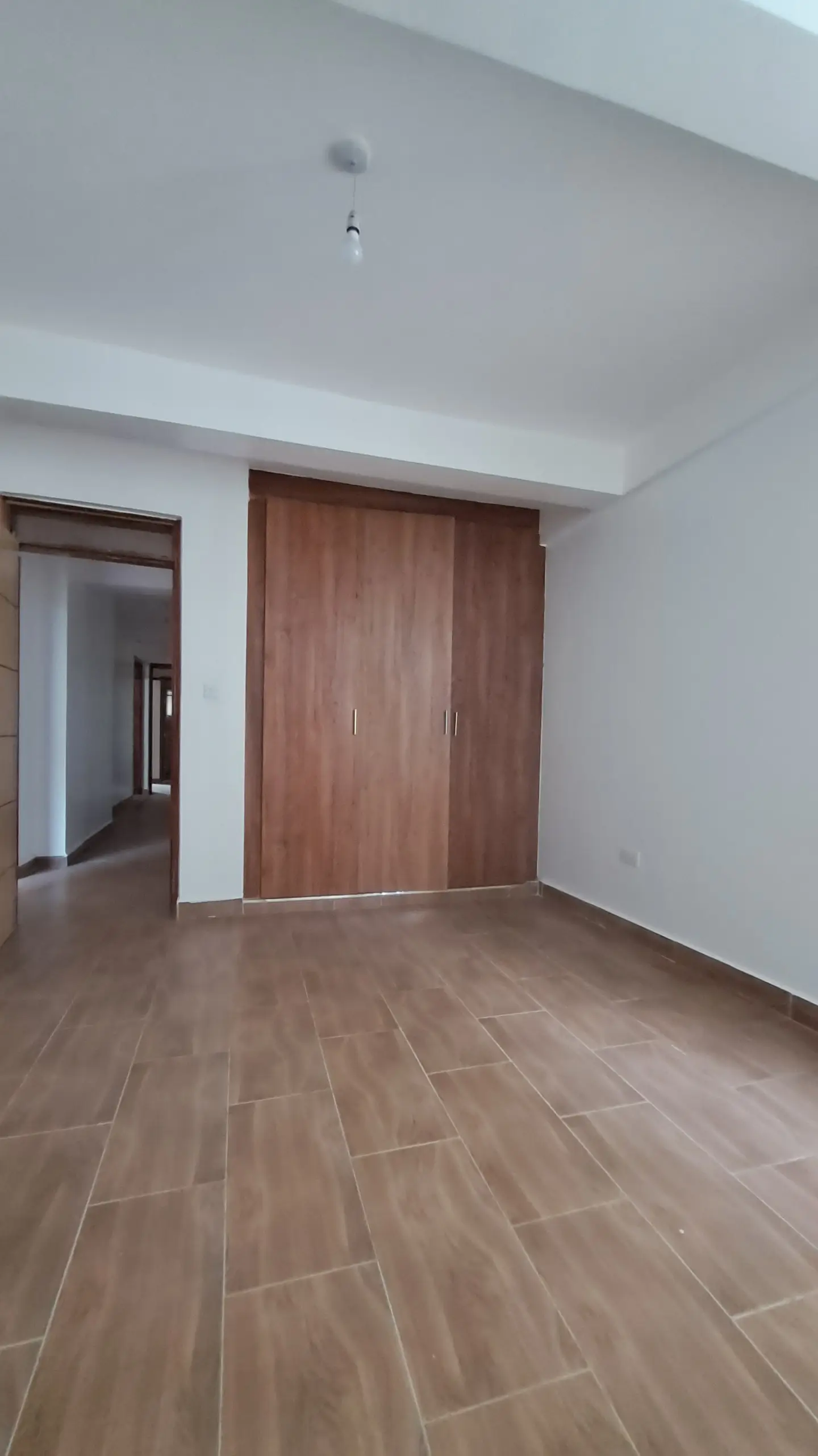 Spacious empty bedroom with wooden herringbone flooring