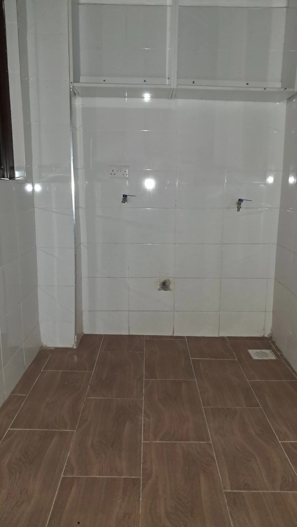 Modern bathroom with white tile shower enclosure and wood-look flooring