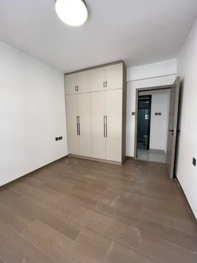 Spacious bedroom with built-in wardrobes and wooden flooring