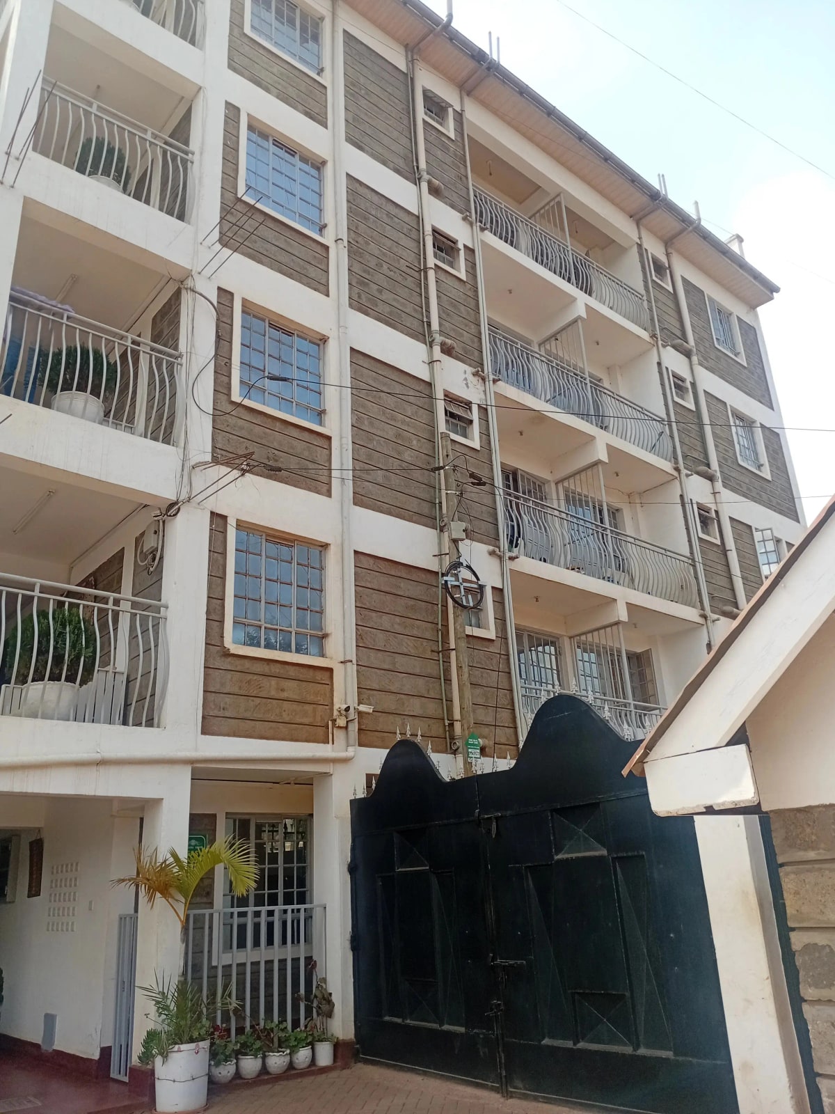 Multi-story residential building with black metal gate entrance