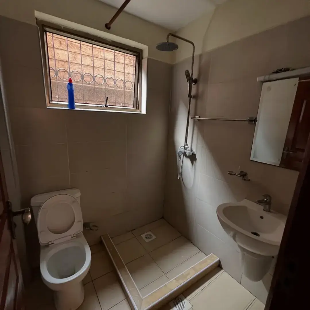 Compact bathroom with toilet, sink, walk-in shower