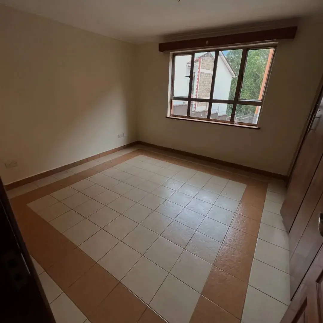 Spacious bedroom with large window and tiled flooring