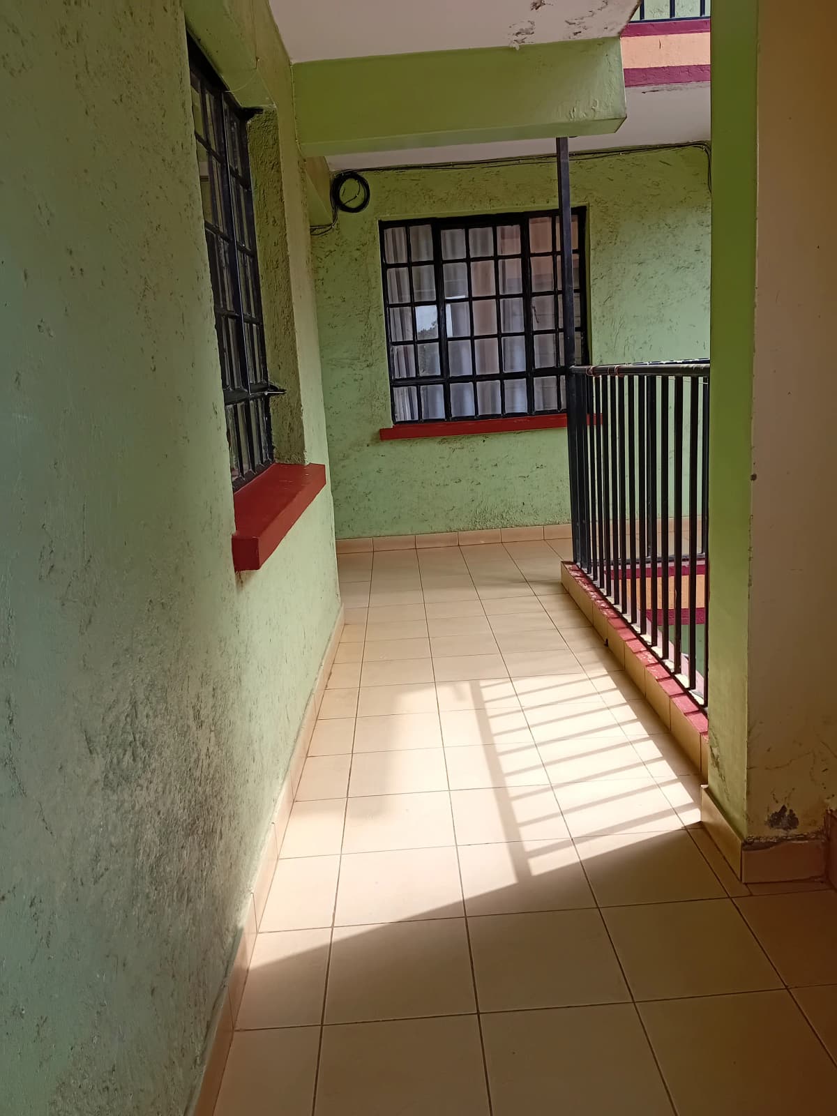 Bright corridor with tiled floor and barred security gate