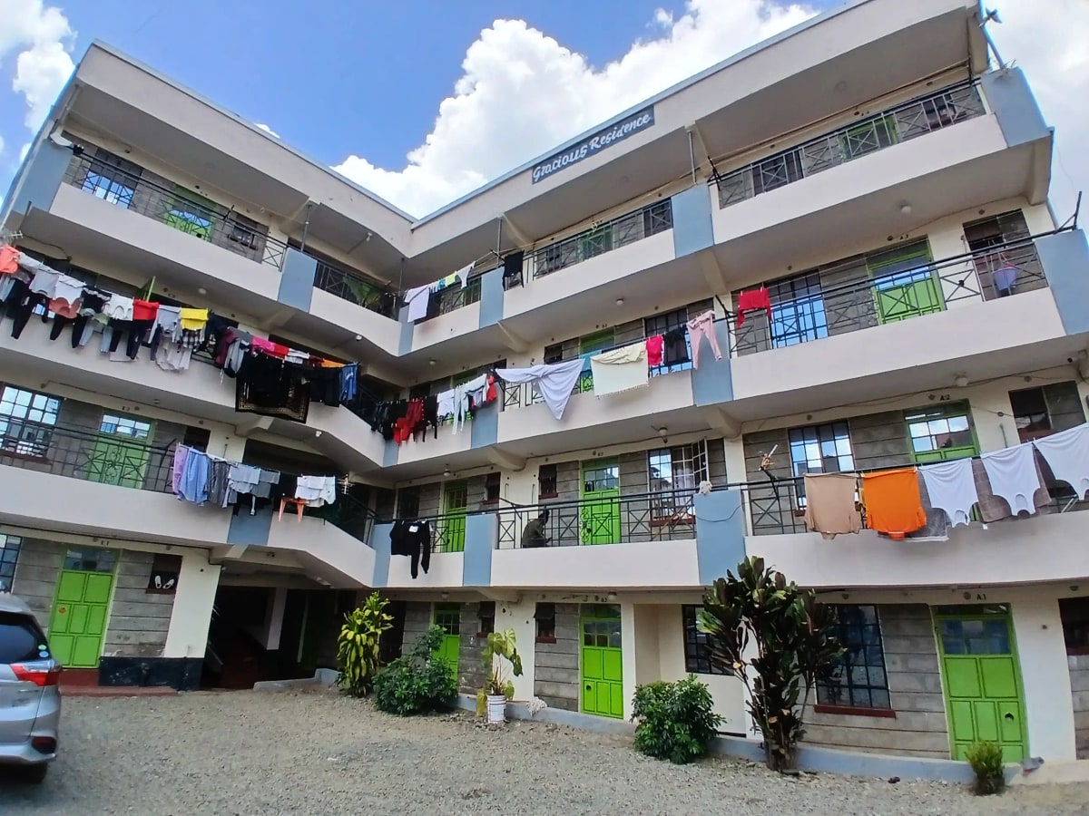Modern multi-story residential building with green entrance doors