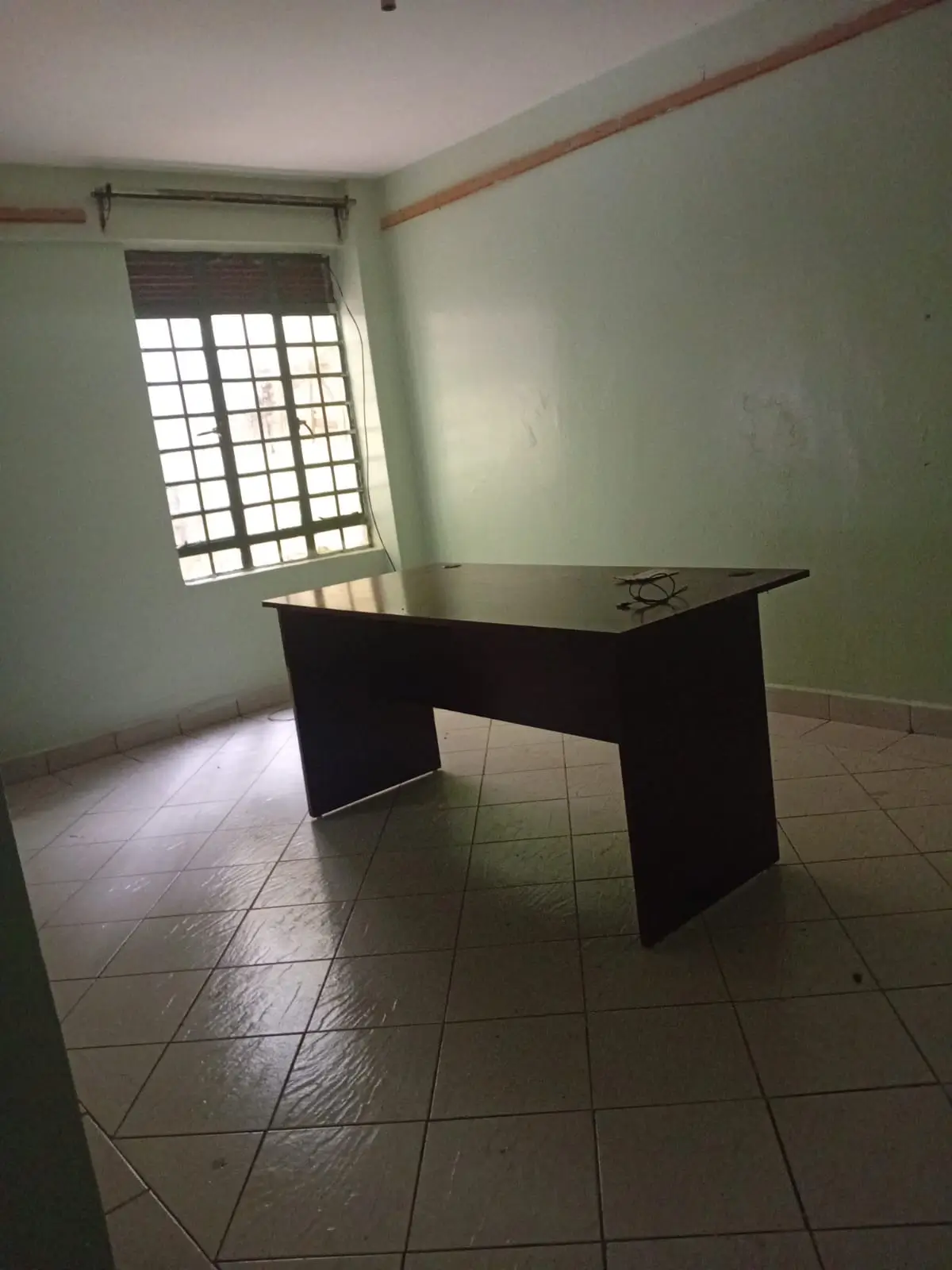 Empty room with black desk and barred window