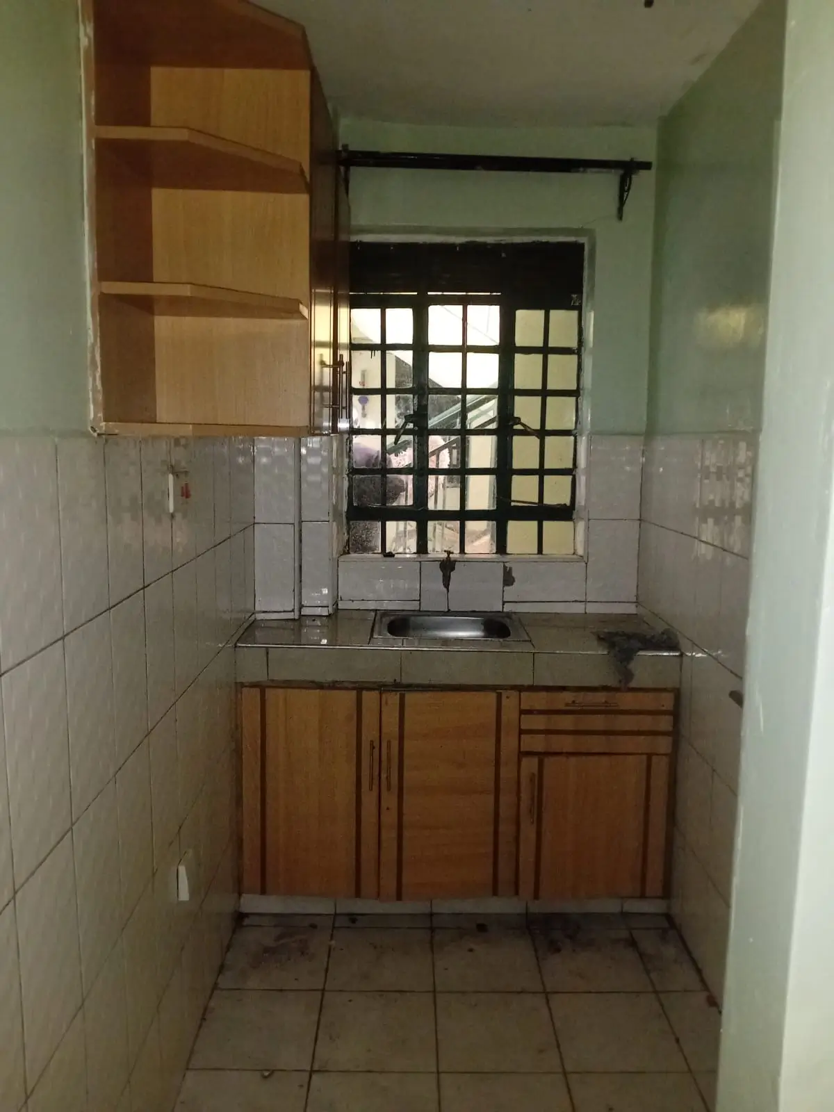 Compact kitchen with wooden cabinets and tiled walls