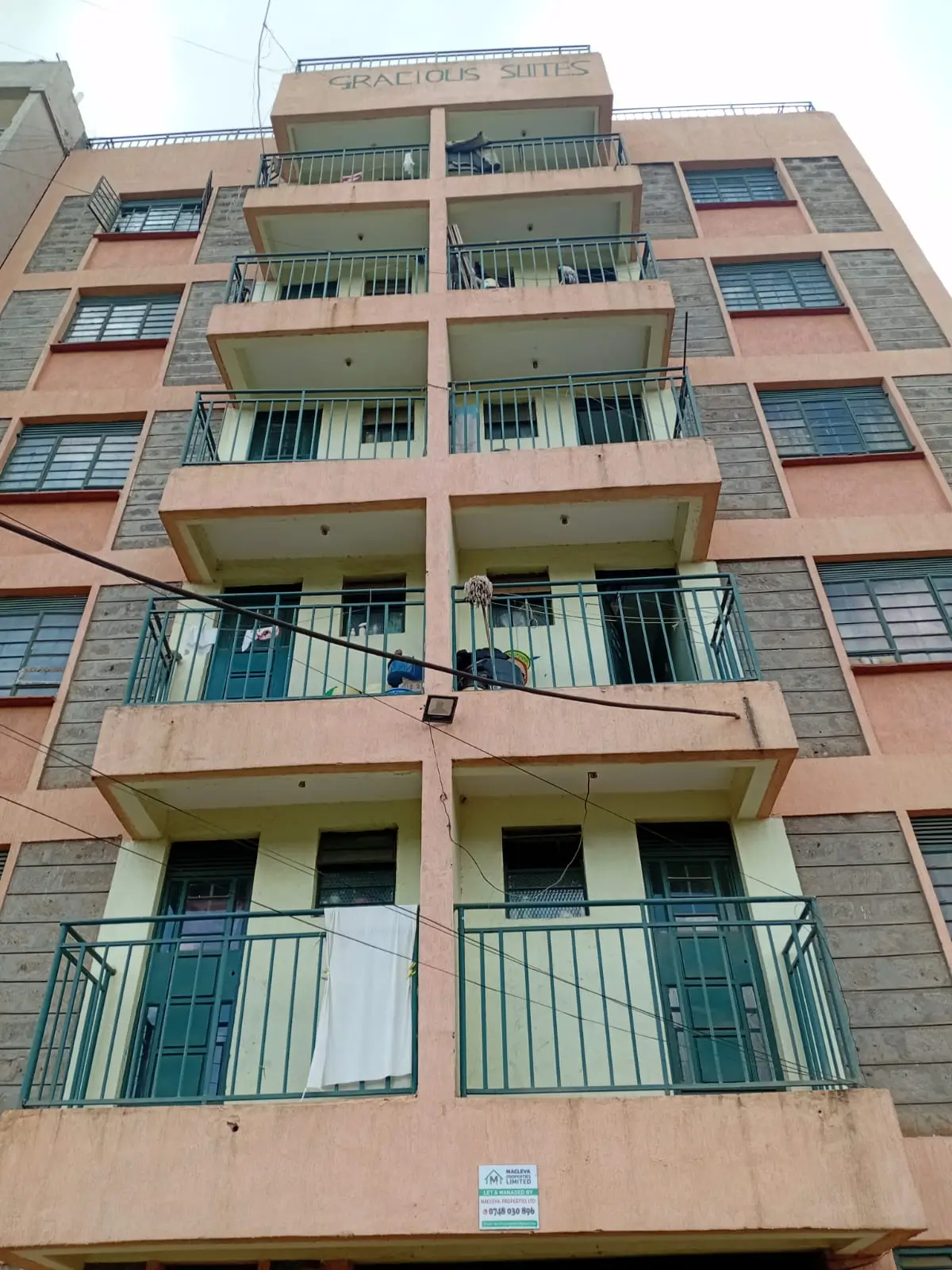 Multi-story residential building facade with green balconies