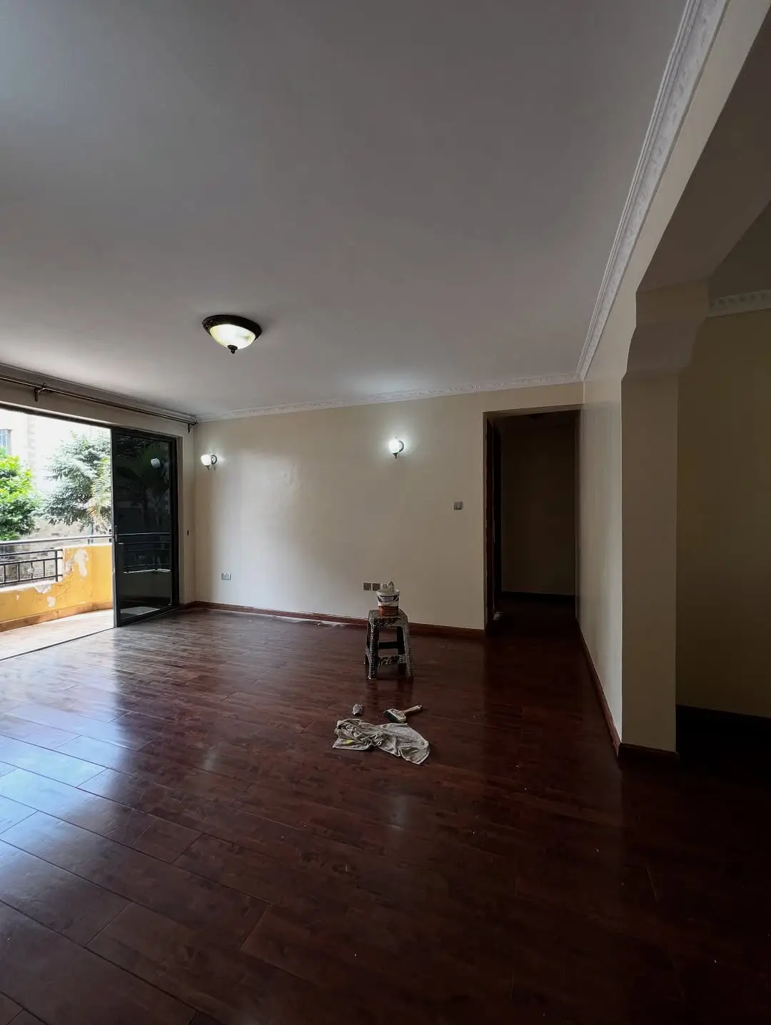Spacious living room with dark wood flooring and balcony access