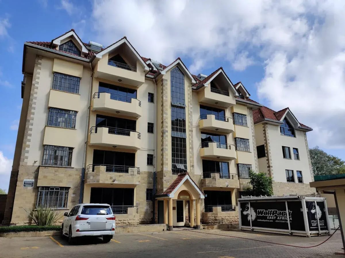 Multi-story residential building facade with balconies and parking