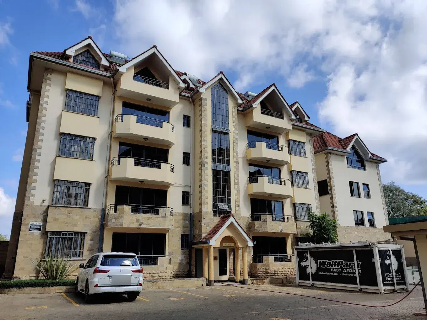 Multi-story residential building facade with balconies and parking