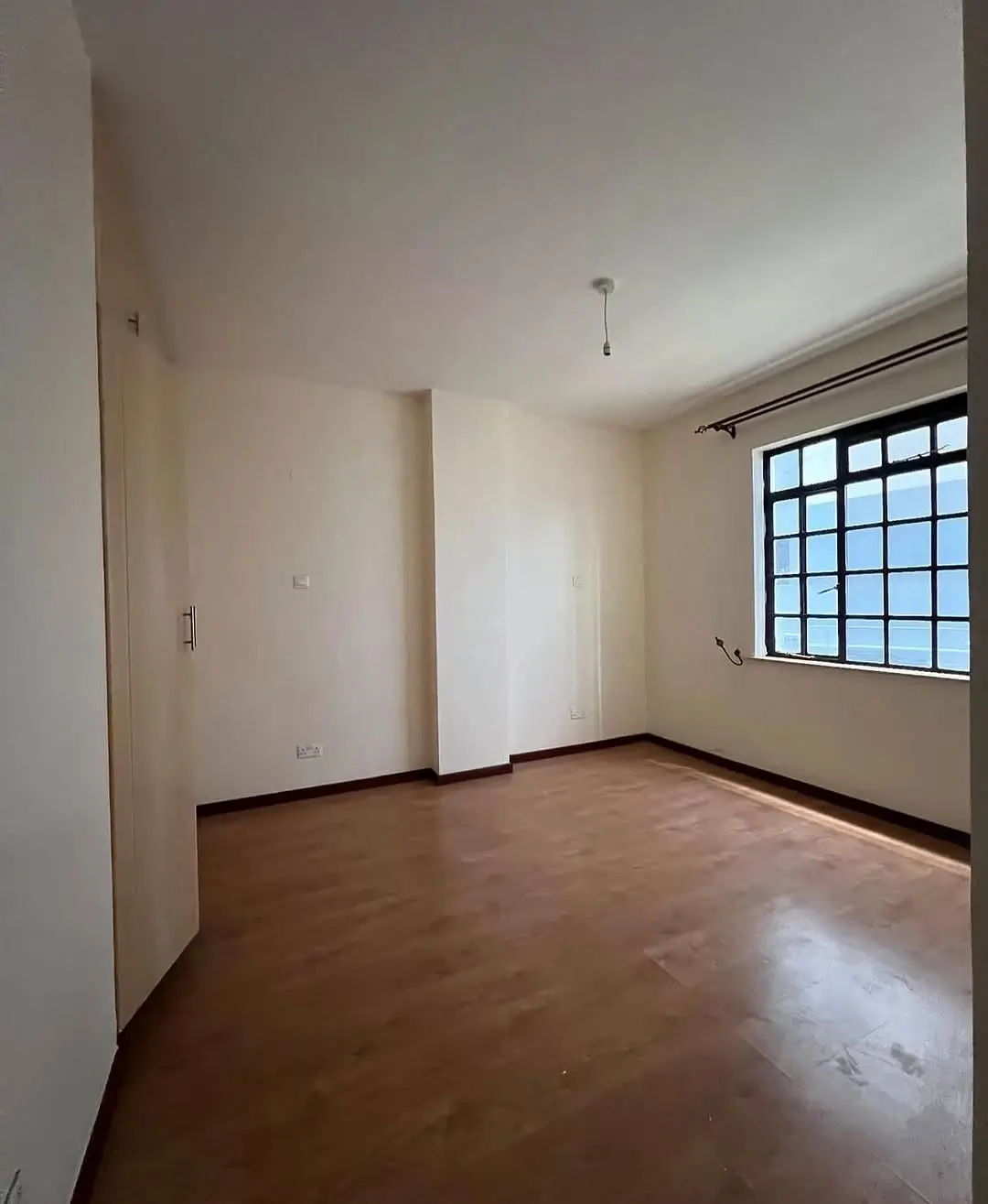 Spacious empty living room with polished wooden floors and natural light
