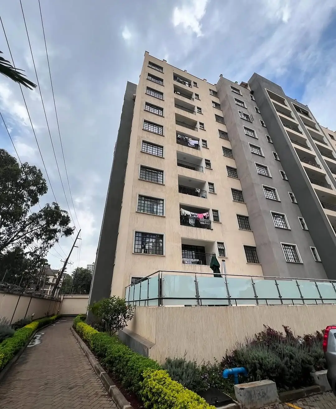 Multi-story residential building facade with manicured grounds