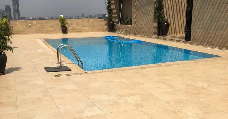 Rectangular swimming pool with deck and surrounding landscape