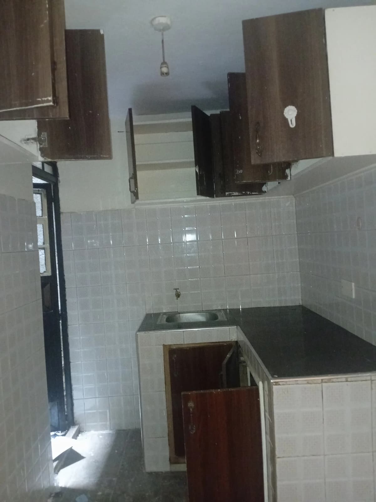 Compact kitchen with white tile walls and dark cabinetry