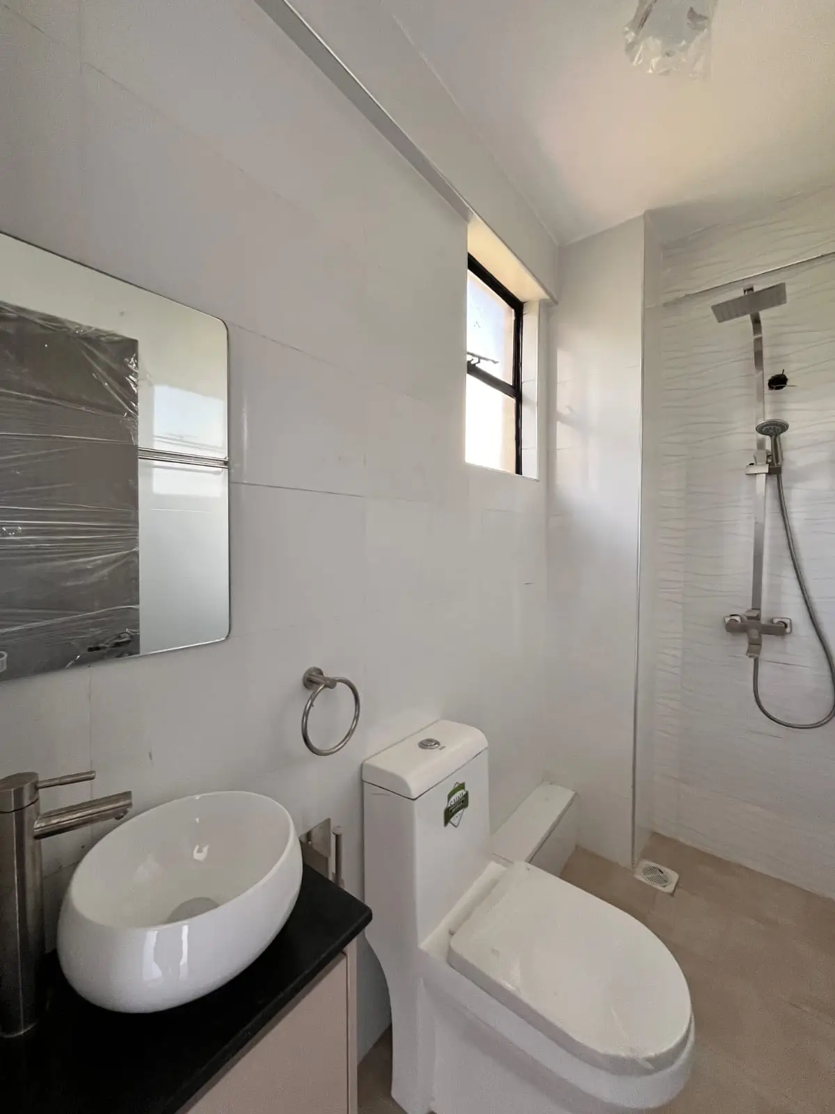 Modern bathroom with vessel sink, toilet, and walk-in shower