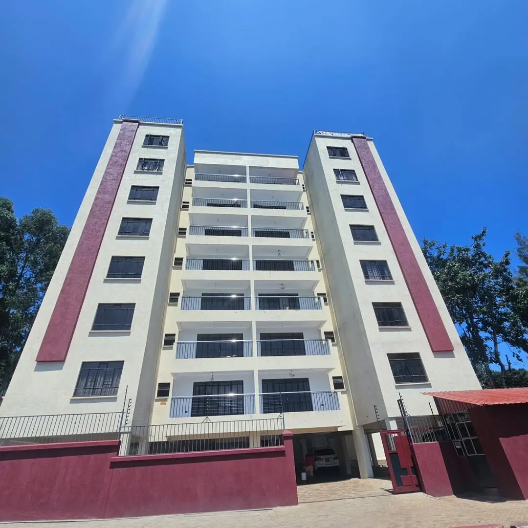 Multi-story residential building with purple accent panels, clear blue sky