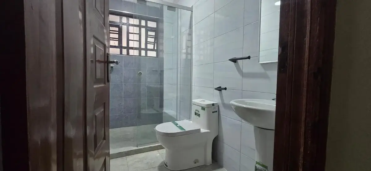 Modern bathroom with glass shower enclosure and dual sink vanity